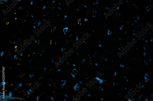 Abstract black and blue rippled background texture. Surface of water frozen in time, hi contrast lighting exposes the fascinating patterns created by soundwaves traveling directly through it. 