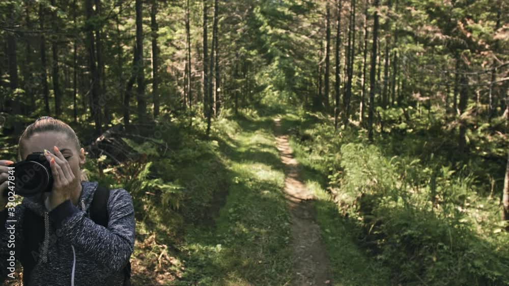 Traveler photographing scenic view in forest. One caucasian woman shooting nice magic look. Girl take photo video on dslr mirrorless camera. Professional photographer travel with backpack. Outdoor. Traveler photographing scenic view in forest. One caucasian woman shooting nice magic look. Girl take photo video on dslr mirrorless camera. Professional photographer travel with backpack. Outdoor.