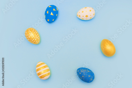 Easter golden and blue decorated eggs on blue