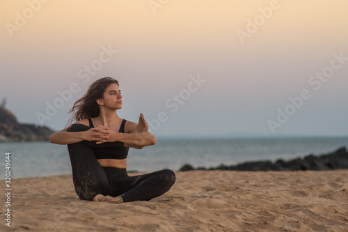 Young woman stretching on the beach