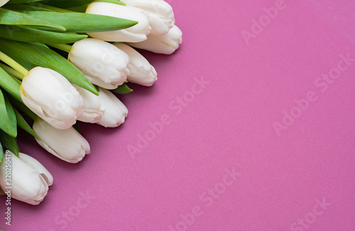 Fototapeta Naklejka Na Ścianę i Meble -  A bouquet of white tulips and a red velvet heart on a pink background-the concept of Valentine's Day.