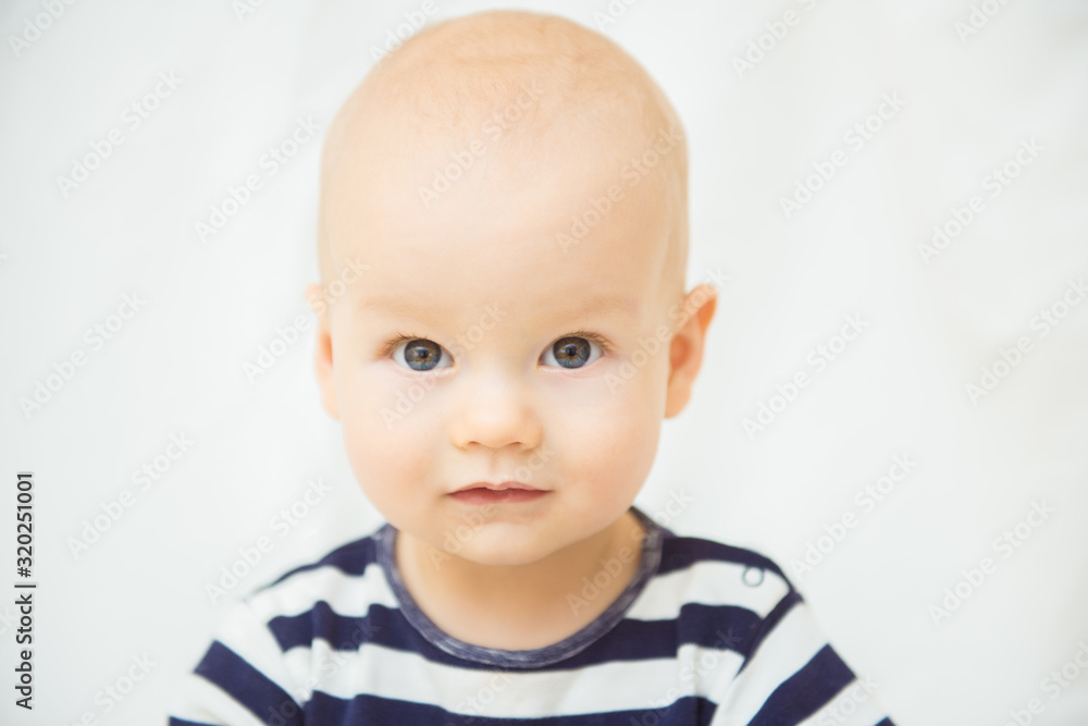 Portrait of a cute baby boy. Adorable one year old child looking funny and curious