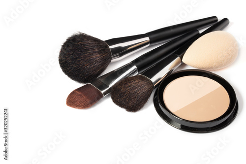 Loose powder, various makeup brushes. Makeup artist accessories isolated on white background. Products for perfect facial skin makeup.
