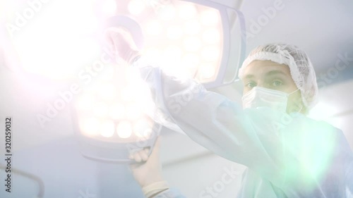 surgeon in the operating room turns on the light