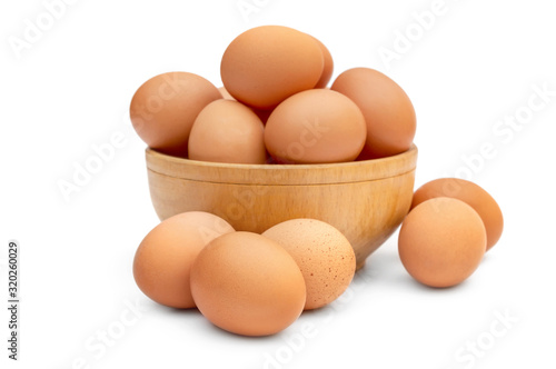 Wooden bowl with eggs on white.