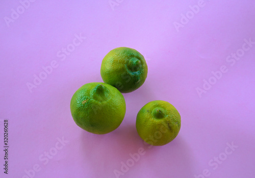 Isolated Mexican Lima, mousambi, common sweet lemon on a violet background, scientific name Citrus limetta photo
