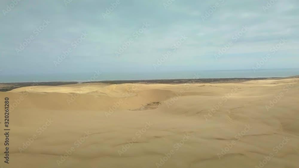 Aerial view ascending over the Giant Sand Dunes at Te Paki, New Zealand Aerial view ascending over the Giant Sand Dunes at Te Paki, New Zealand