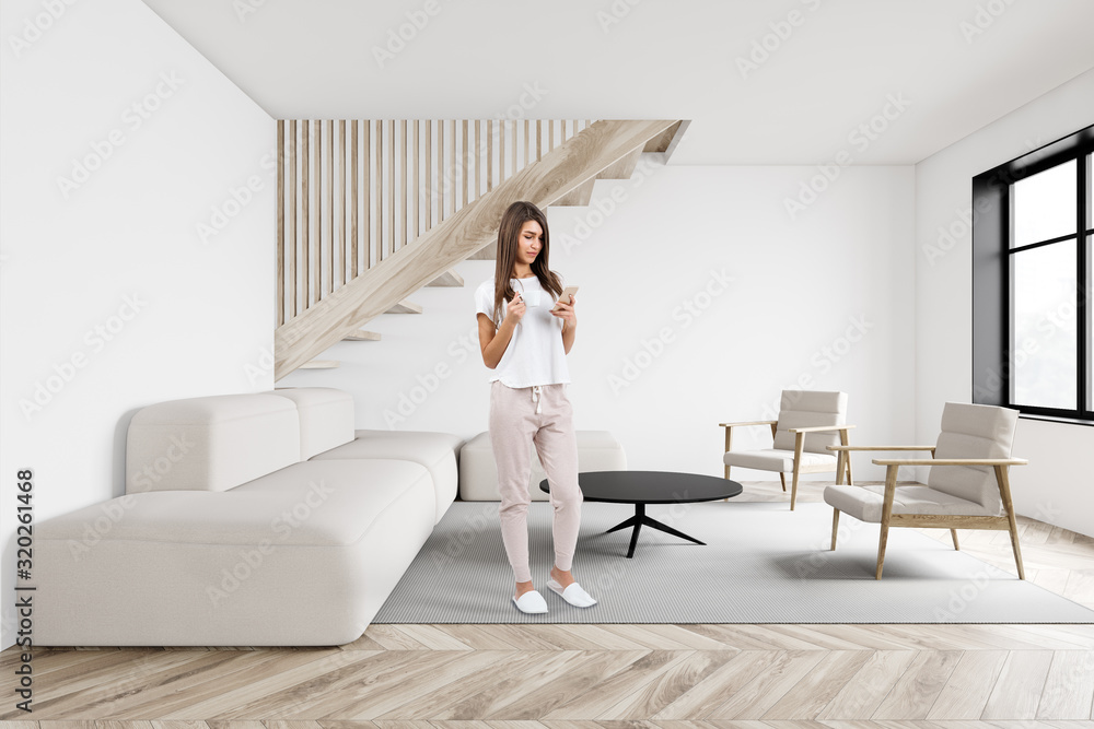Young woman in white living room Young woman in white living room