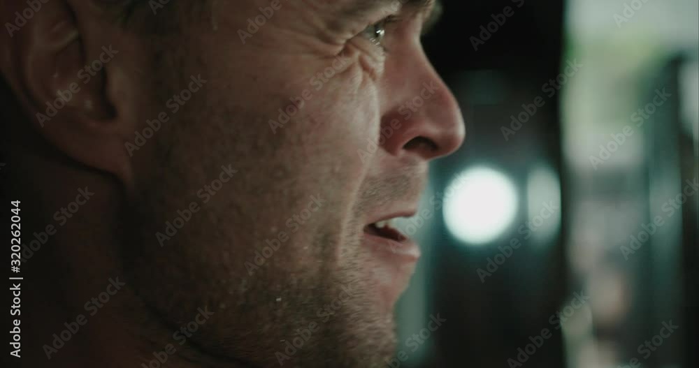 Close up of man's face while lifting weights in slow motion. Strained facial expressions Close up of man's face while lifting weights in slow motion. Strained facial expressions