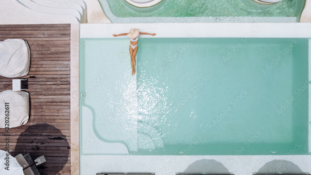 Φωτογραφία Woman in straw hat relaxing in clear pool water in hot sunny day on Bali villa