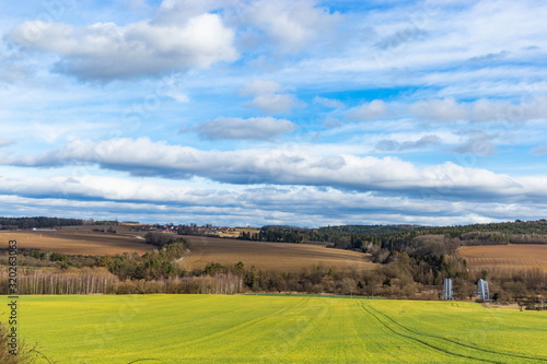 Early spring landscape in South Bohemia. Green field and forest. Blue sky. © Sergey Fedoskin