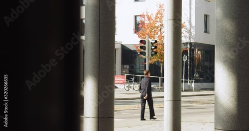 Wallpaper Mural Business man wearing a suit walking through a building to a meeting. Torontodigital.ca
