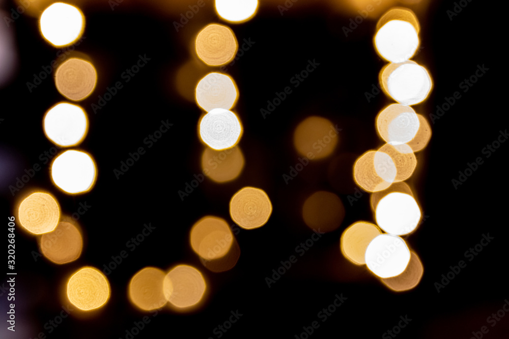 Fototapeta premium Weihnachtlich funkelnde und strahlende Lichter als schönes Bokeh vor dunklem Hintergrund verschönern die Adventszeit mit Glanz und Gloria