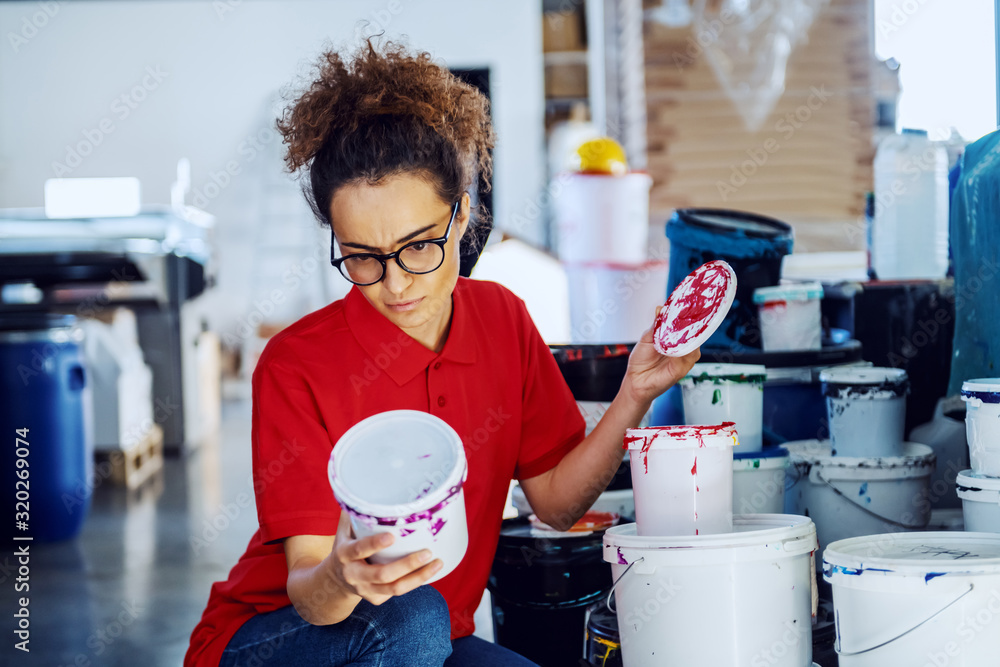 Beautiful caucasian female employee crouching next to buckets with ...