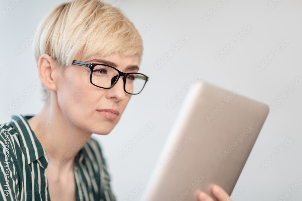 Lady In Eyeglasses Using Tablet Squinting Eyes Sitting Indoor Lady In Eyeglasses Using Tablet Squinting Eyes Sitting Indoor