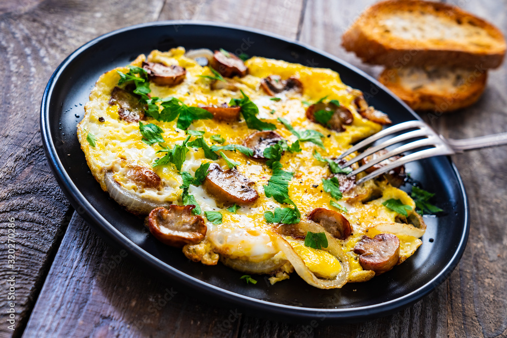 Breakfast - omelette with champignon on wooden background Breakfast - omelette with champignon on wooden background