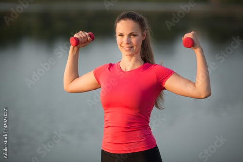 Bild auf Leinwand beautiful young woman in sportswear is engaged in summer training in a park near
