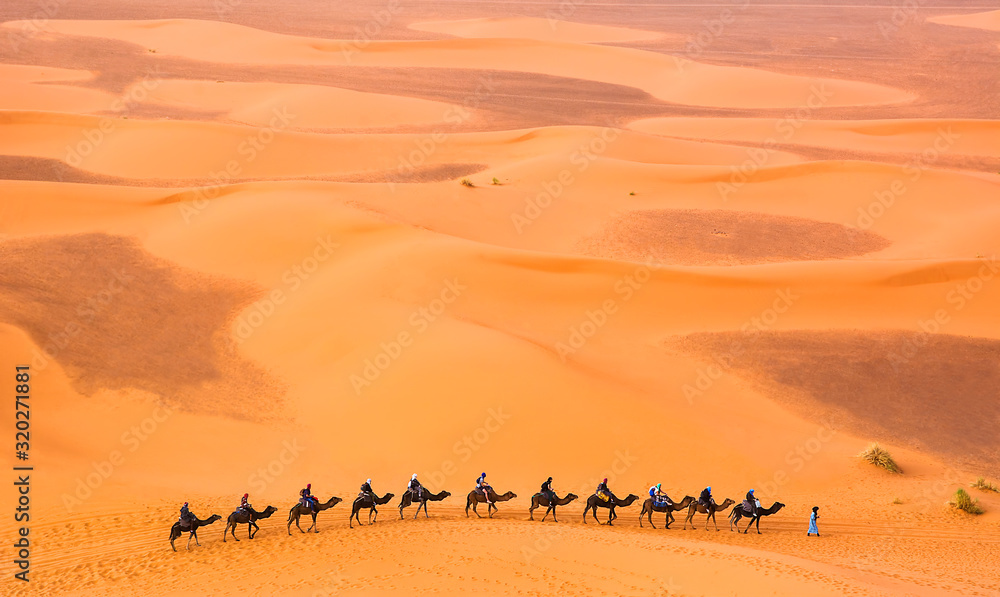 Camel caravan with travelers among the sand dunes in beautiful Sahara Desert. Amazing view nature of Africa. Travel concept. Artistic picture. Beauty world. - obrazy, fototapety, plakaty 