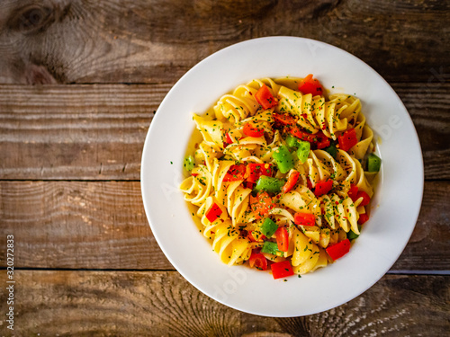 Pasta with vegetables on wooden background