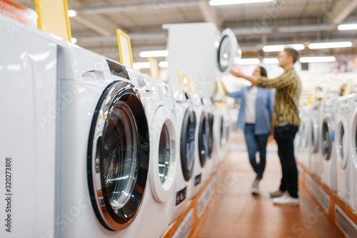 фотографія Couple choosing washing machine, electronics store