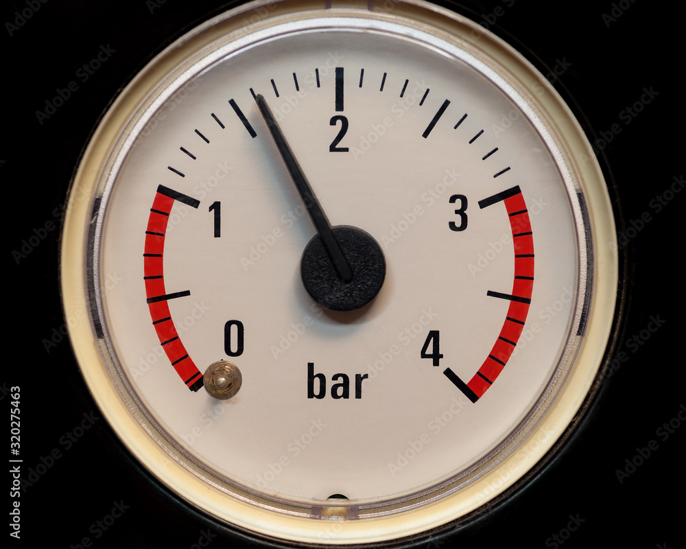 The pressure gauge dial with red band to control the water pressure. Closeup. The pressure gauge dial with red band to control the water pressure. Closeup.