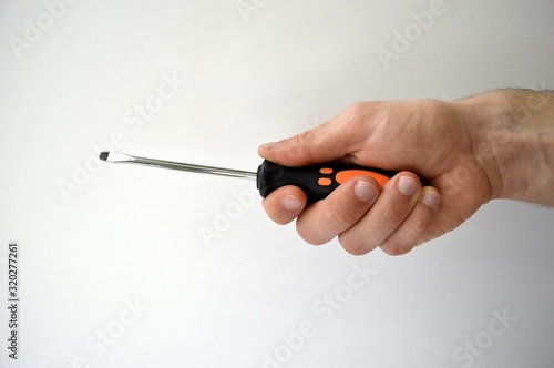 Fototapeta Male's hand holding screwdriver isolated on white background