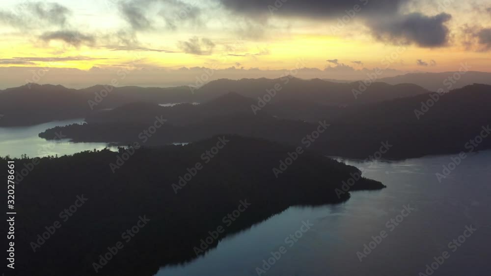 A serene sunrise illuminates the dramatic tropical islands within Raja Ampat, Indonesia. This beautiful region is thought to be the world's epicenter of marine biodiversity. A serene sunrise illuminates the dramatic tropical islands within Raja Ampat, Indonesia. This beautiful region is thought to be the world's epicenter of marine biodiversity.