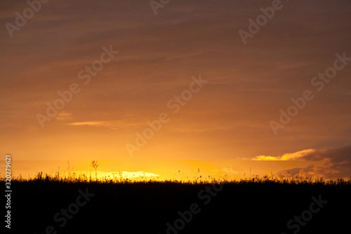 Beautiful colorful gradient sunset over field. Nature landscape sunset background