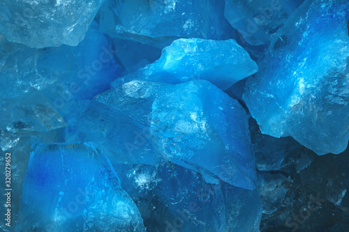 Pieces of crushed blue ice glass cracks background texture. close-up frozen water