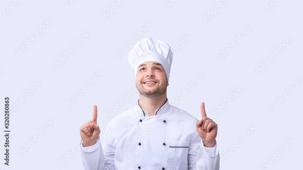 Chef Guy Pointing Fingers Upward Standing Over White Background, Panorama Chef Guy Pointing Fingers Upward Standing Over White Background, Panorama