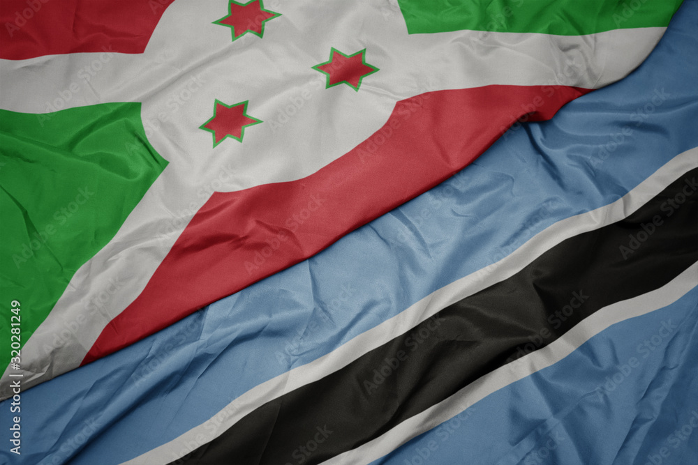 waving colorful flag of botswana and national flag of burundi .