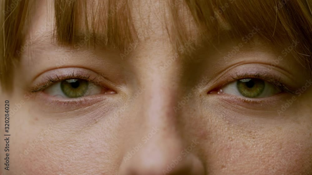 Beautiful green eyes of pretty girl. Close-up. The woman with bangs looks in camera. Emotions with the eyes Beautiful green eyes of pretty girl. Close-up. The woman with bangs looks in camera. Emotions with the eyes