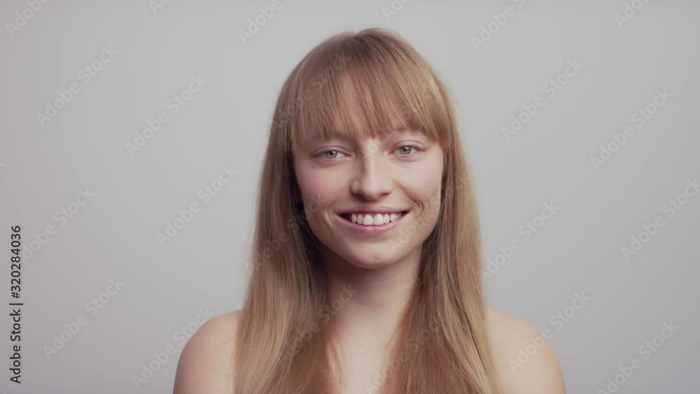 Woman smiling and looking at the camera in a studio in slow motion. Woman smiling and looking at the camera in a studio in slow motion.