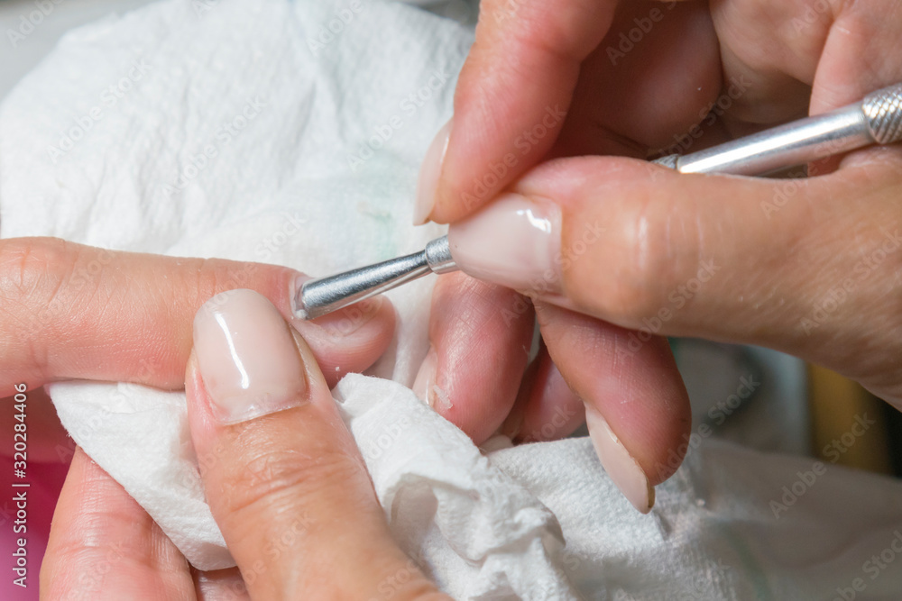 The process of removing cuticles in a beauty salon. Close-up The process of removing cuticles in a beauty salon. Close-up