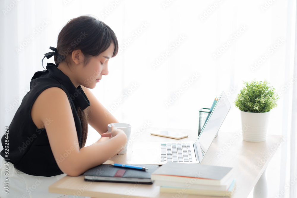 Beautiful young freelance asian woman smiling working and on laptop computer at desk office with professional, girl using notebook and drink coffee, business and lifestyle concept. Beautiful young freelance asian woman smiling working and on laptop computer at desk office with professional, girl using notebook and drink coffee, business and lifestyle concept.