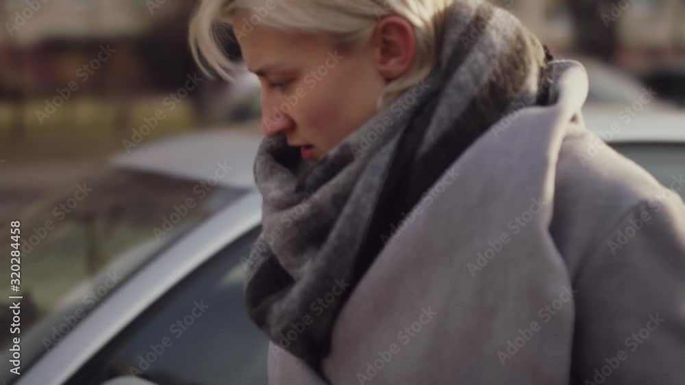 Young Woman Examines Front of Car After Being in an Accident Young Woman Examines Front of Car After Being in an Accident