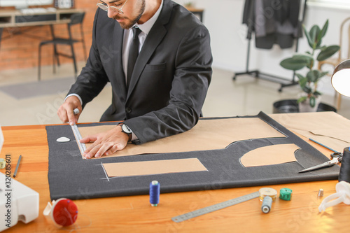 Young tailor working at tab...