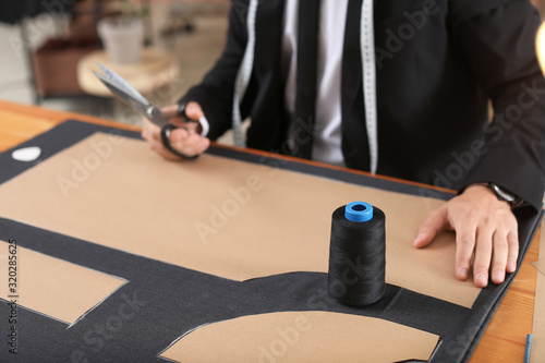 Young tailor working at tab...