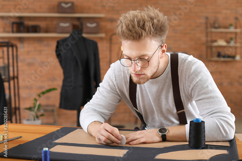Young tailor working at tab...