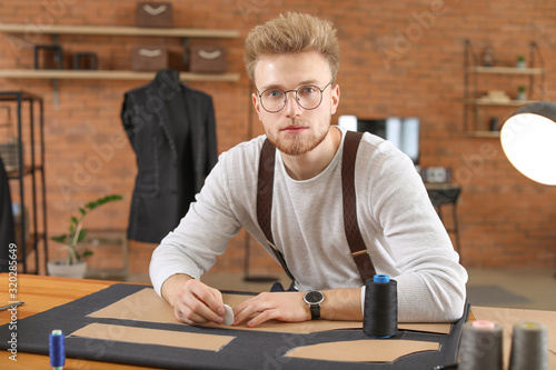 Young male tailor with bear...