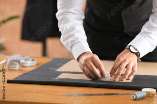 Young tailor working at tab...