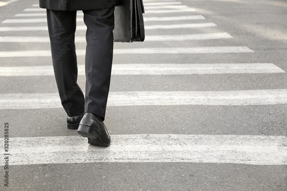 Young businessman crossing road. Concept of choice Young businessman crossing road. Concept of choice
