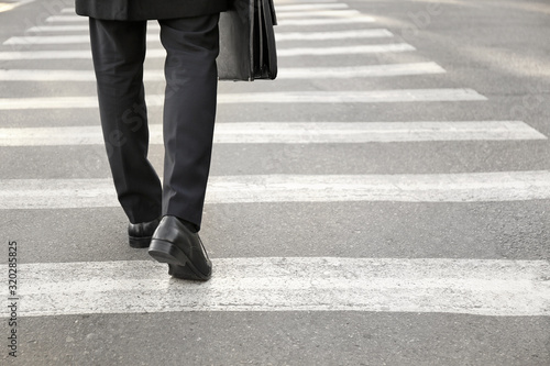 Young businessman crossing road. Concept of choice