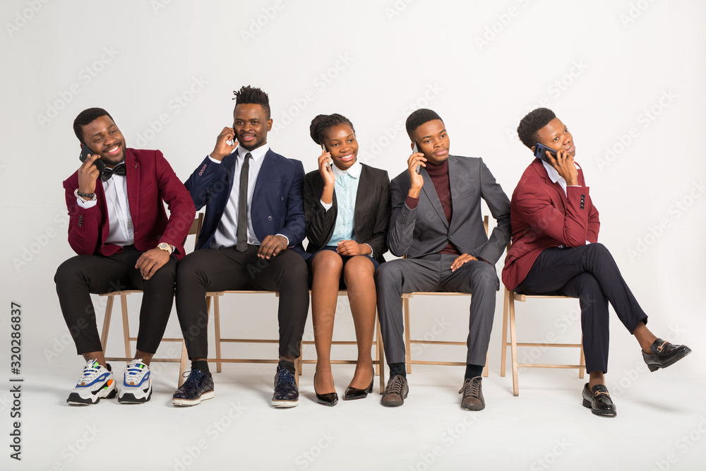 Obraz premium beautiful african people in suits on a white background with phones in their hands