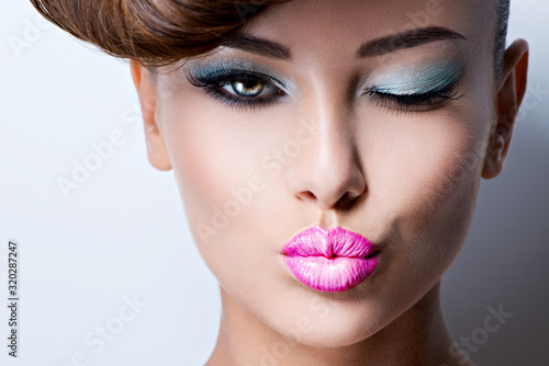Vászonkép face of beautiful flirting woman with fashion bright eye makeup