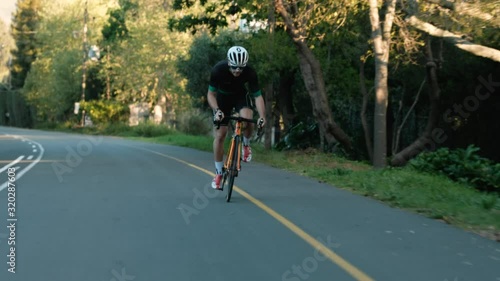 Wallpaper Mural Tracking Shot of a Young Male Road Cyclist Racing Up a Hill Torontodigital.ca