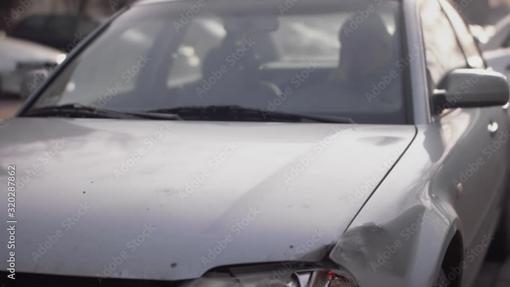 Tilt Up From Broken Car Lights To Reveal Women Driver Stressed On Phone Inside. Slow Motion Tilt Up From Broken Car Lights To Reveal Women Driver Stressed On Phone Inside. Slow Motion