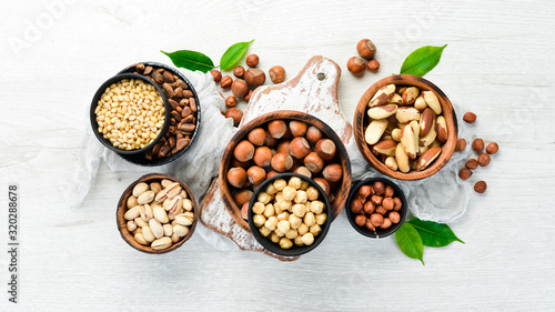 Assortment of nuts in bowls on white wooden background. free space for your text. Top view.