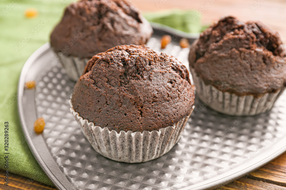 Plate with tasty chocolate muffins on table, closeup Plate with tasty chocolate muffins on table, closeup