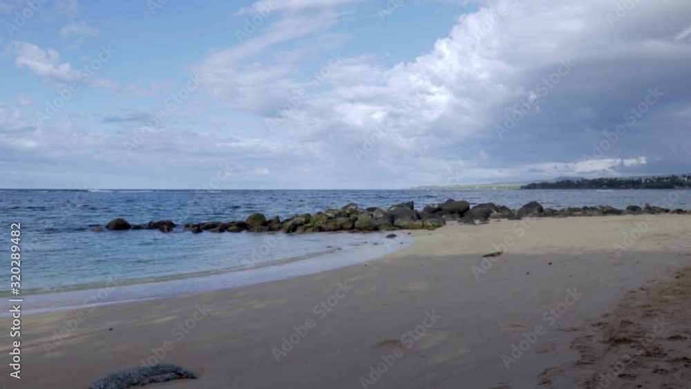Landing plane flying low over ocean. Volcanic rock and sandy beach in foreground. Landing plane flying low over ocean. Volcanic rock and sandy beach in foreground.